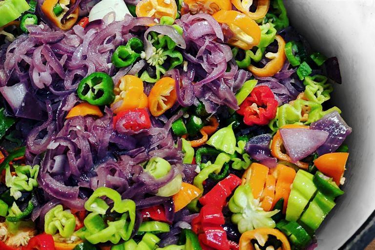 An iridescent array of chilies, onions, and garlic, slowly sweating over a low heat